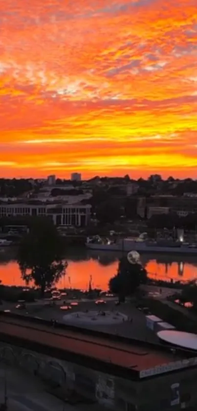 Orange sunset cityscape reflecting in river.