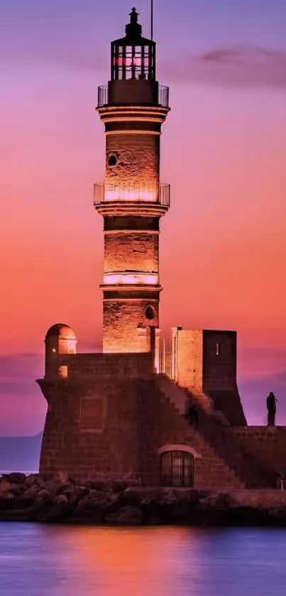 Lighthouse against a vibrant sunset over a calm ocean.