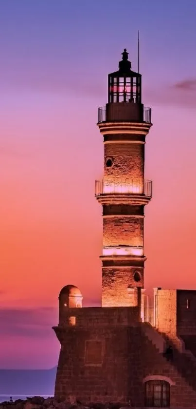 Lighthouse at sunset with orange and purple sky over calm ocean waters.