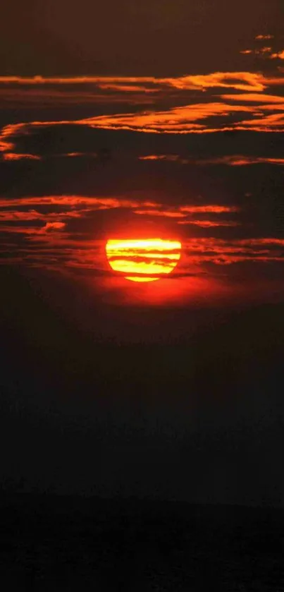 Vibrant orange sunset with clouds over a serene sky.