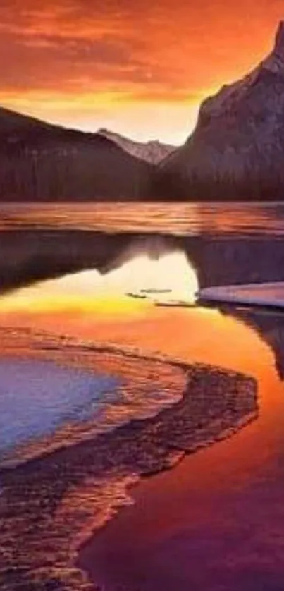 Fiery sunset reflecting over a mountain lake.