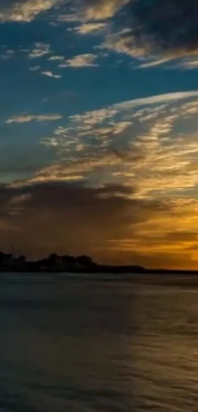 Golden sunset over an ocean horizon, with clouds reflecting light.