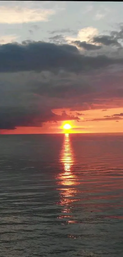 Stunning sunset over ocean with vivid orange and blue hues.