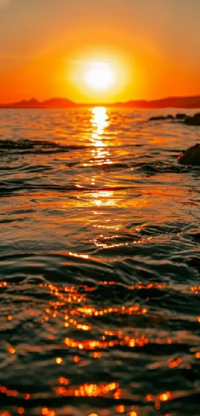 Beautiful sunset over ocean with orange reflections on the water.