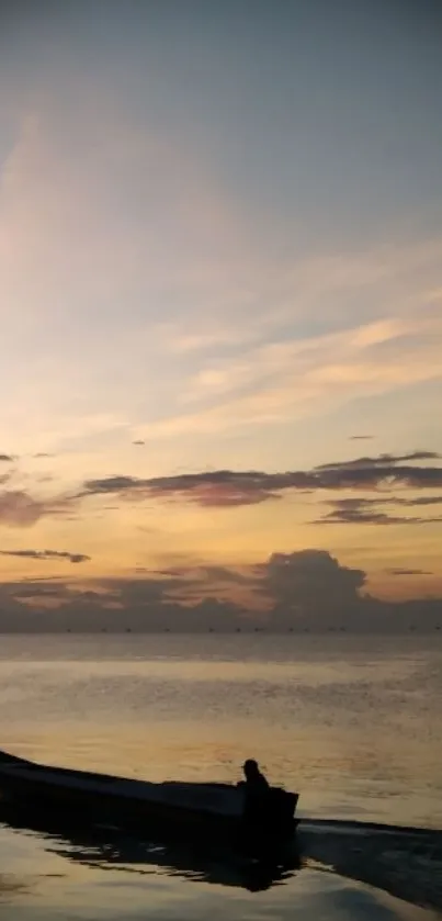 Sunset over calm sea with a silhouette boat