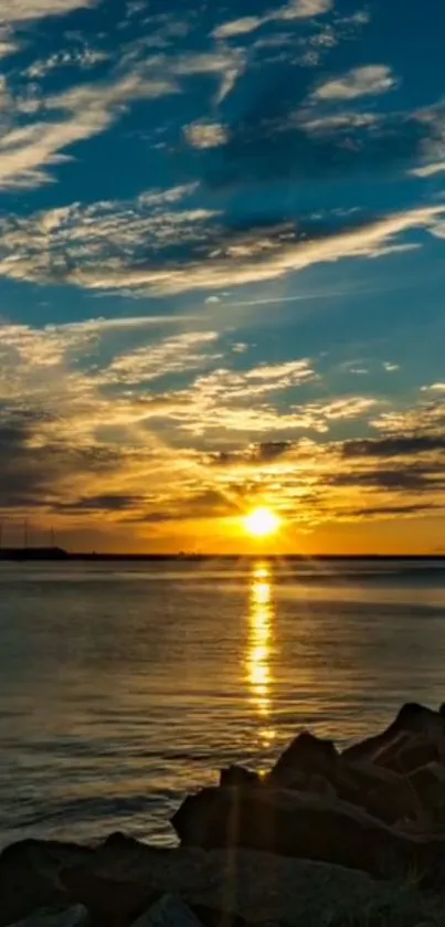 Beautiful sunset over calm ocean with glowing sky and clouds.