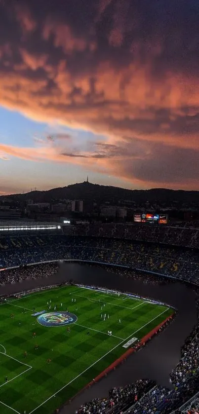 Aerial view of a football stadium beneath a stunning orange sunset.