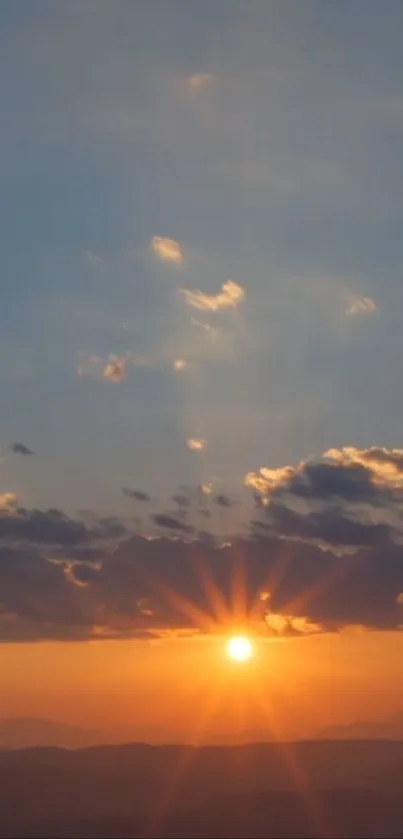 Beautiful sunset over mountains with an orange and blue sky.