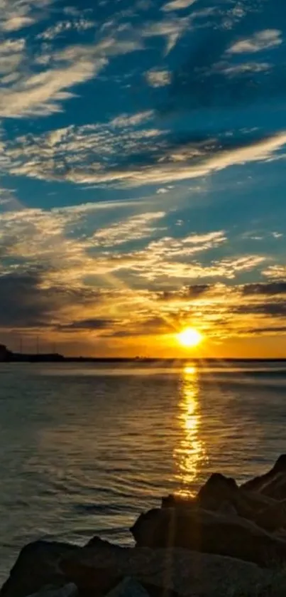 Beautiful sunset over an ocean with rocks in the foreground.