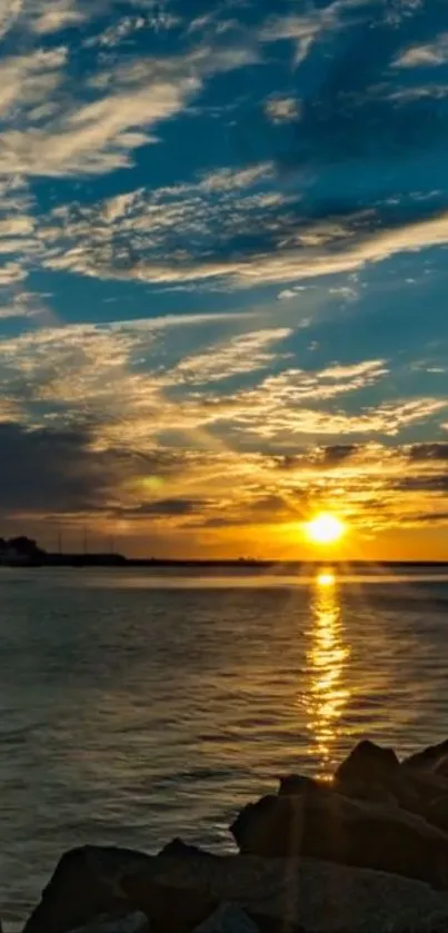 Sunset over ocean with clouds and vibrant colors reflecting on water.