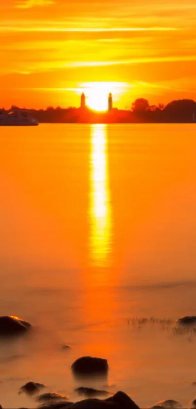 Vibrant orange sunset over a tranquil lake with vivid reflections.