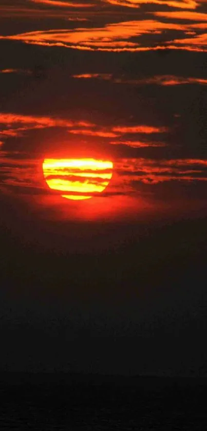 Fiery sunset over calm ocean horizon.