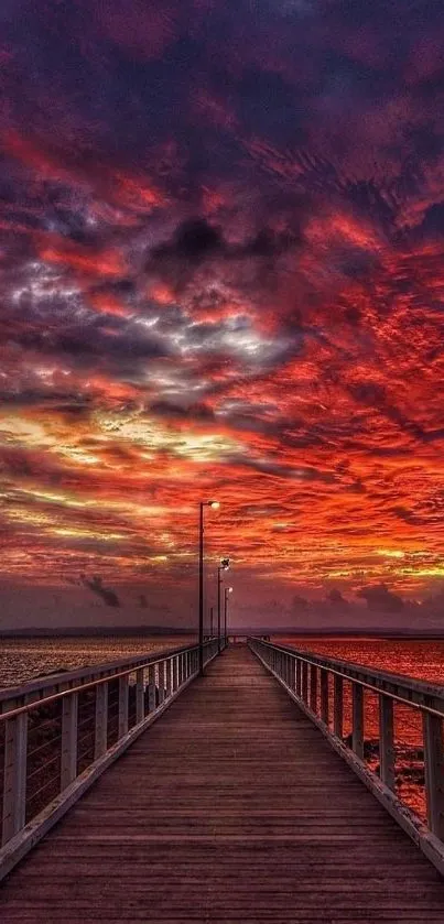 Spectacular crimson sunset over a pier, perfect mobile wallpaper.