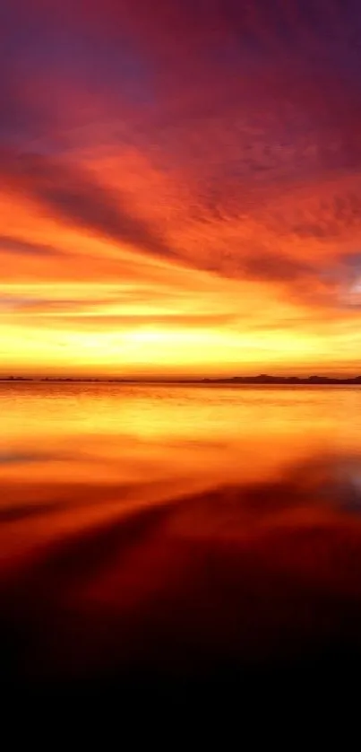 Orange sunset reflecting on calm waters with vibrant sky.