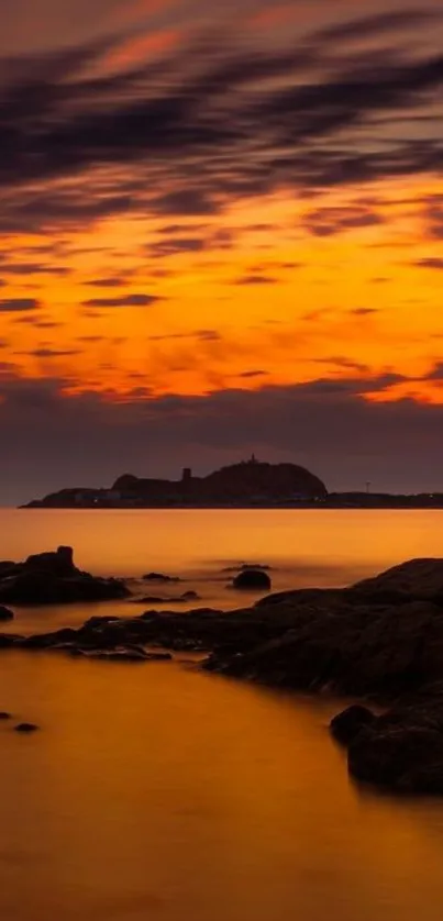 Sunset over a rocky seascape with vibrant orange hues.