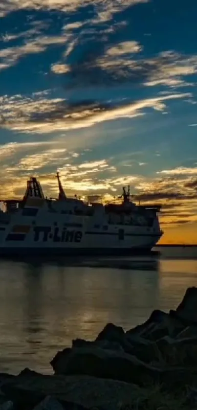 Silhouette of a ship at sunset with a navy blue sky and calm waters.