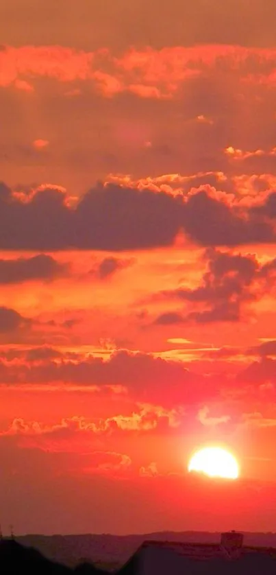 Vibrant orange sunset with clouds glowing in the evening sky.