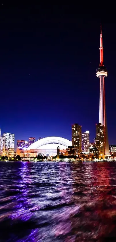 Toronto skyline at night with city lights reflecting on water.