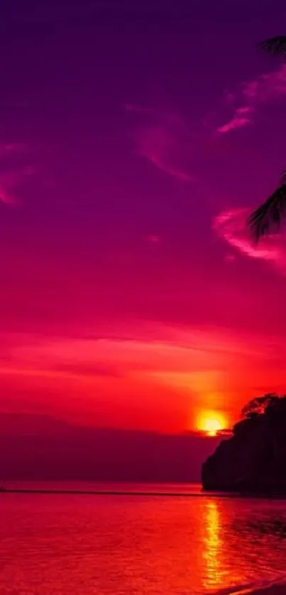 A vibrant tropical sunset with pink and purple hues over a tranquil beach.