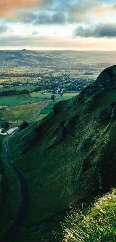 Scenic valley with lush green hills and a winding road under dramatic clouds.