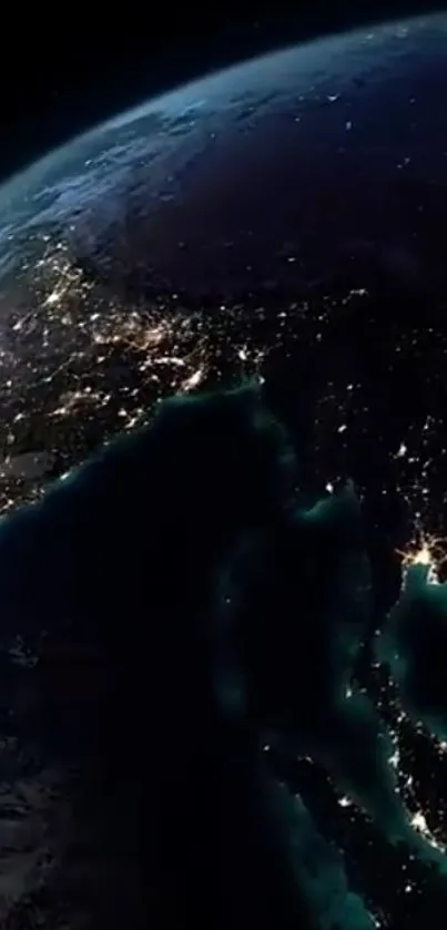 Satellite view of Earth at night, highlighting illuminated cityscapes.