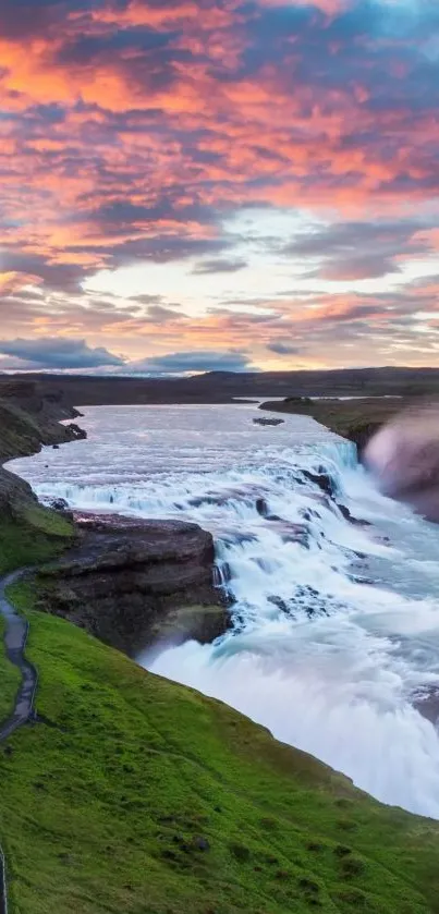 Beautiful waterfall under a vibrant sunset sky with lush surroundings.