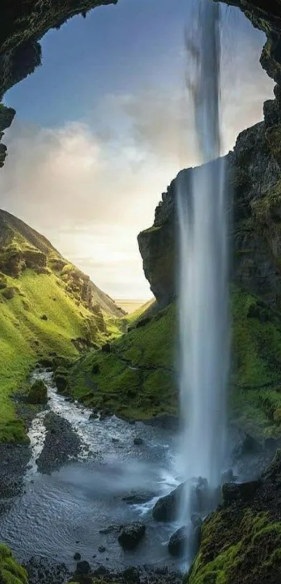 A mesmerizing waterfall view through a green cave opening, perfect for mobile wallpaper.