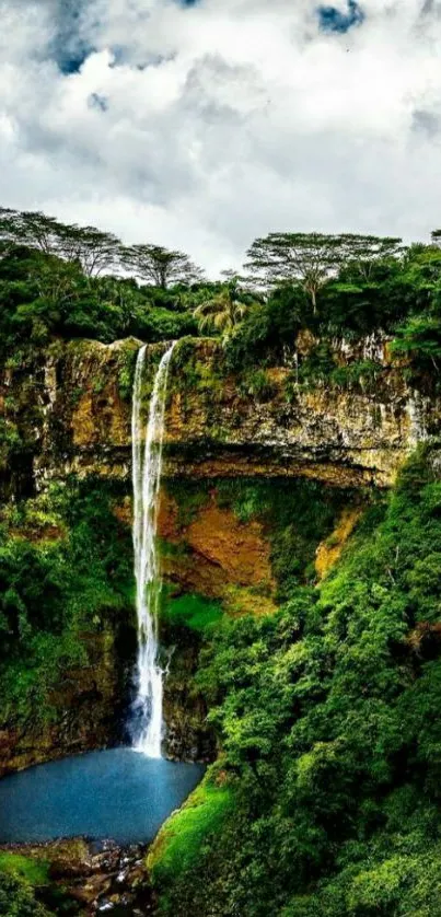 Waterfall in lush forest with dramatic sky.