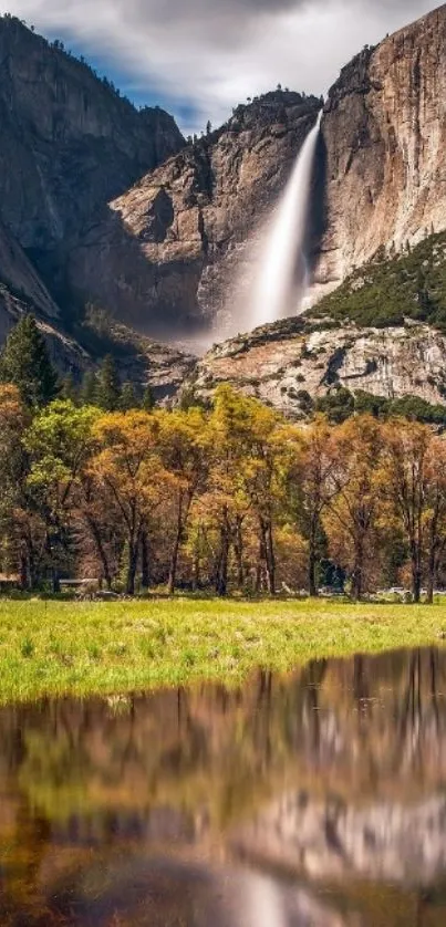 Majestic waterfall in mountain landscape with autumn colors and calm reflection.