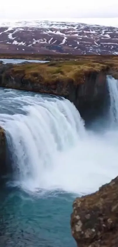 Majestic waterfall cascading over rugged cliffs in a serene natural landscape.