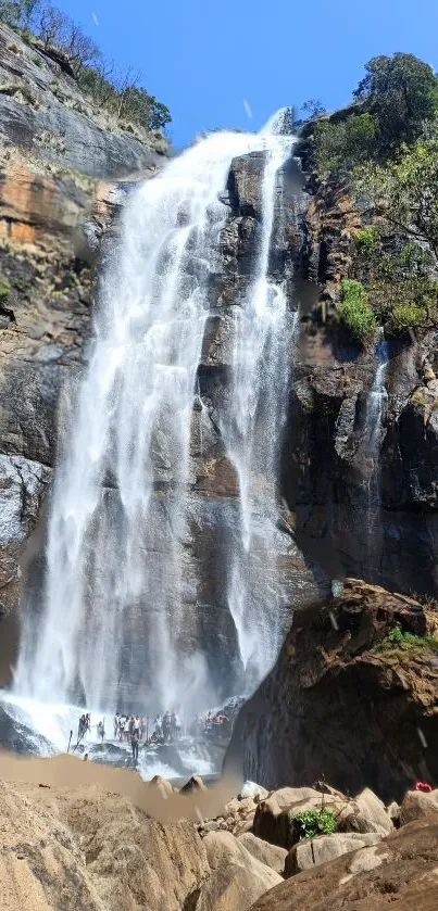 A majestic waterfall cascading down rocky cliffs in a serene natural setting.