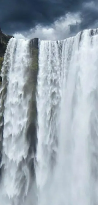 Captivating waterfall with a dramatic gray sky in a mobile wallpaper.