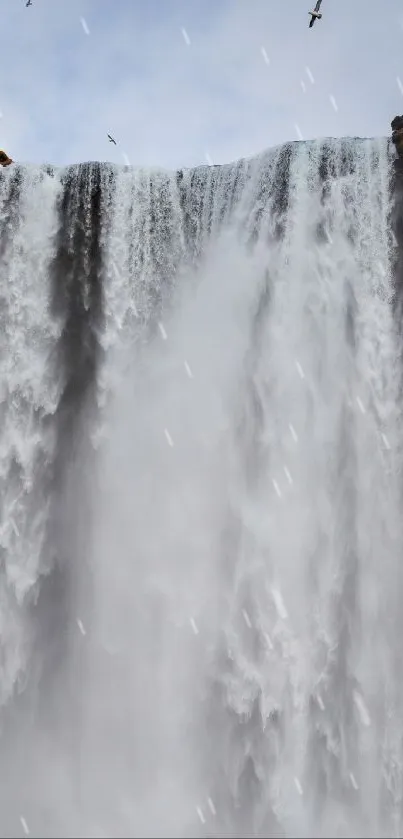 Majestic waterfall cascading with serene skies in the background.