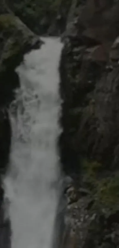 Dark waterfall cascading between cliffs.