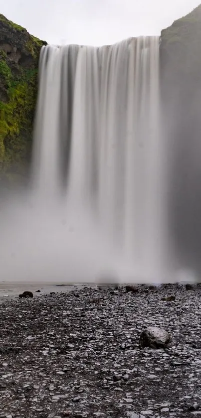 Breathtaking waterfall surrounded by lush green cliffs in a tranquil setting.