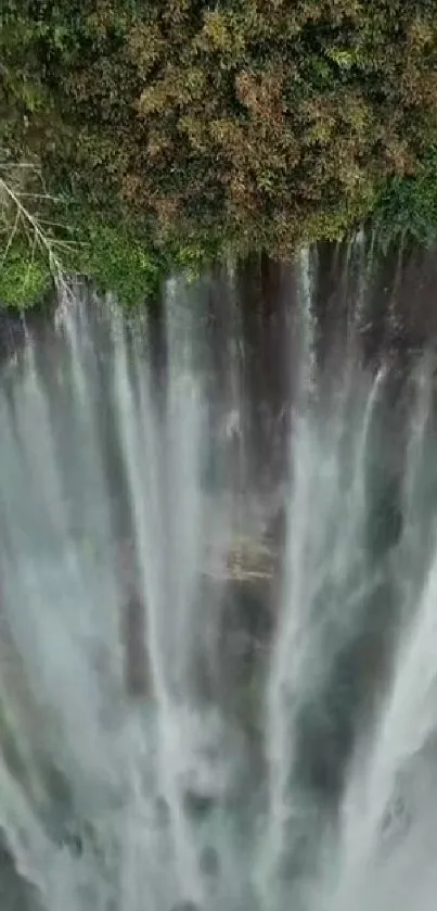 Aerial view of a stunning waterfall surrounded by lush greenery.