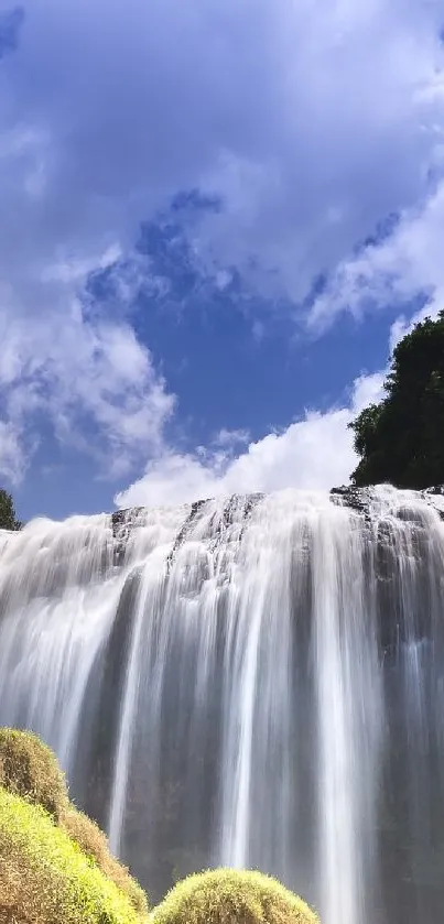 Breathtaking waterfall with blue sky and lush greenery mobile wallpaper.
