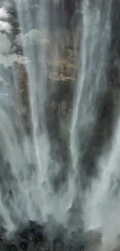 Waterfall cascade with misty effects and serene natural beauty, ideal as phone wallpaper.