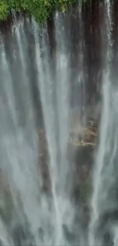 Serene waterfall cascading down lush cliffs.