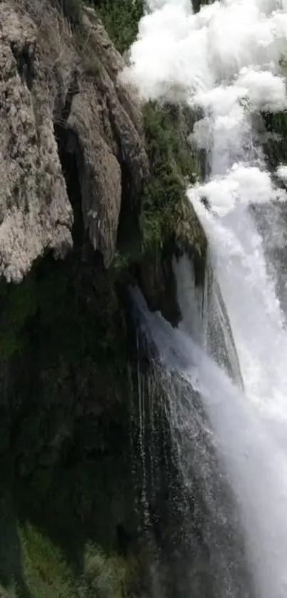 Majestic waterfall cascading over rugged rocks in serene nature setting.