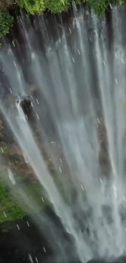 Breathtaking vertical view of a cascading waterfall with lush greenery.