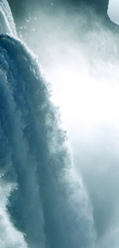 Majestic waterfall flows into misty blue landscape on a mobile wallpaper.