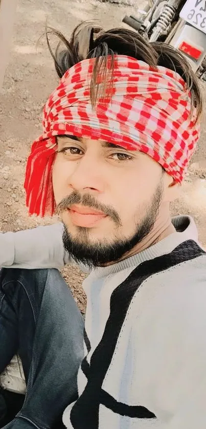 Man with red bandana outdoors, fashion pose.