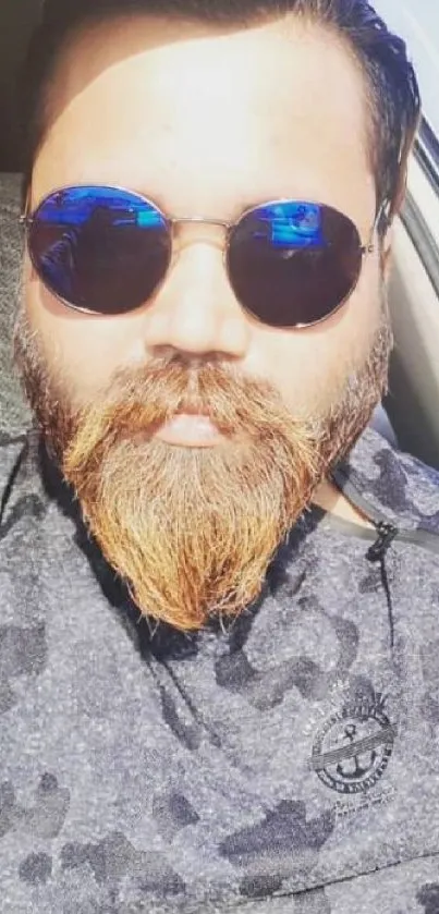 Portrait of bearded man wearing sunglasses in bright sunlight.