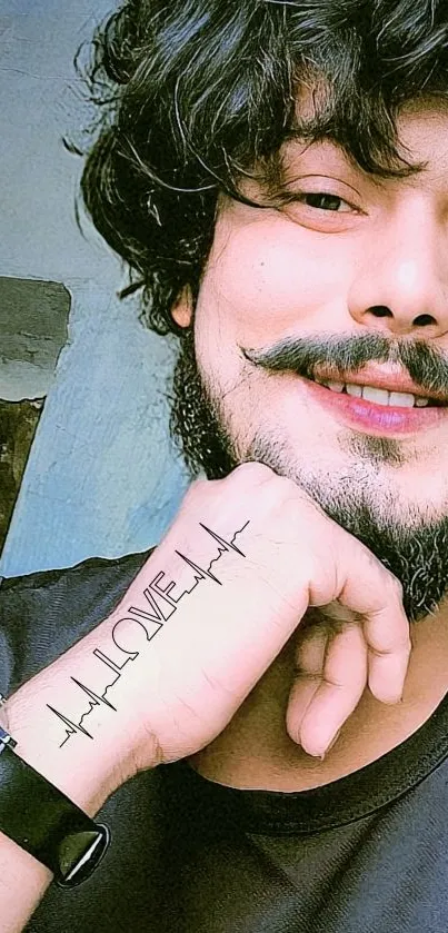 Young man with beard, tattoo, and watch posing stylishly.