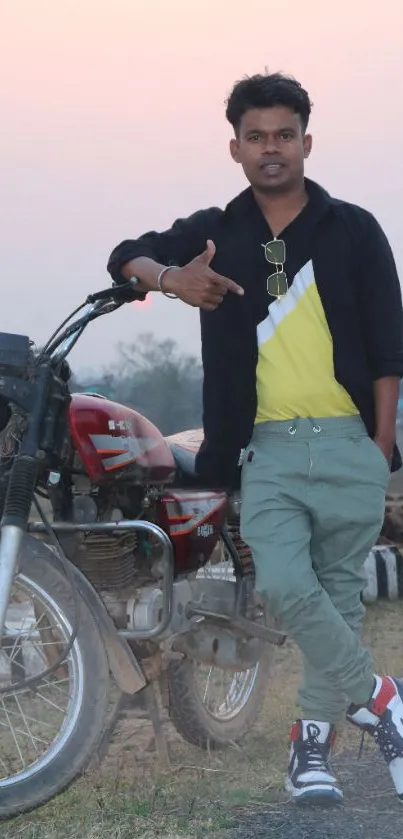 Trendy man in casual outfit with motorcycle in countryside.