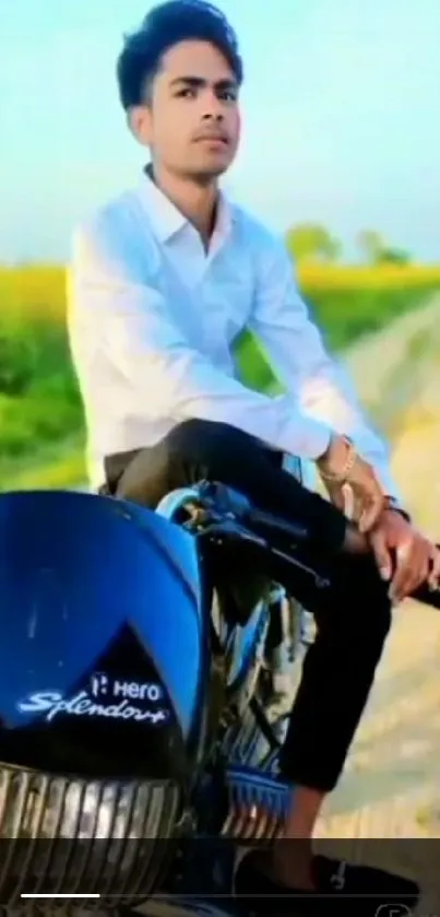 Man sitting on a motorcycle; scenic countryside backdrop