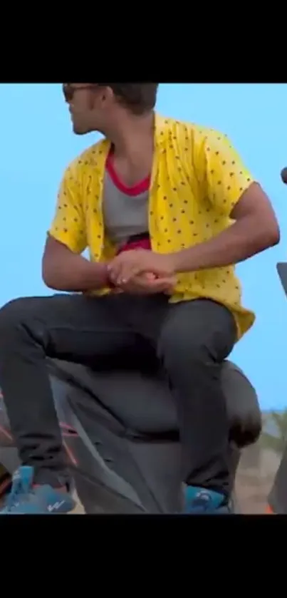 Biker in yellow shirt on a modern motorcycle with a blue sky backdrop.