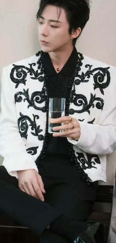 Man in decorative jacket holding a glass