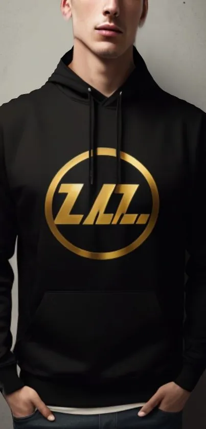 Black hoodie with golden emblem and gray background.